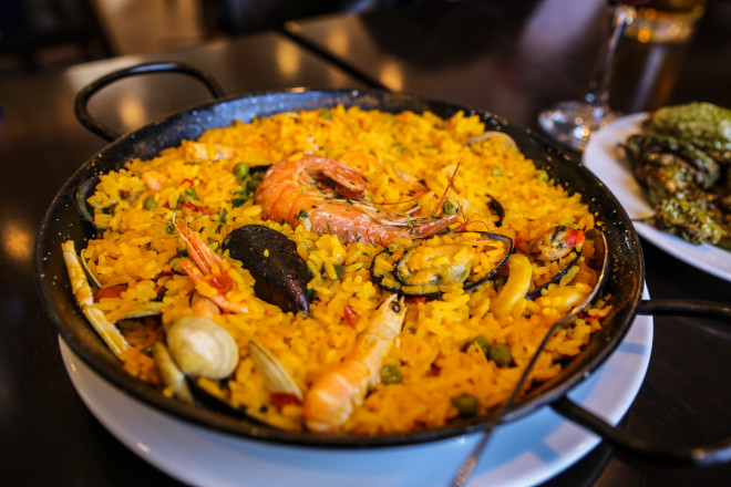 Seafood Paella Paella is a Valencian rice dish that originated in its modern form in the mid-19th century near lake Albufera, a lagoon in Valencia, on the east coast of Spain. Many non-Spaniards view paella as Spain's national dish, but most Spaniards consider it to be a regional Valencian dish. Valencians, in turn, regard paella as one of their identifying symbols.